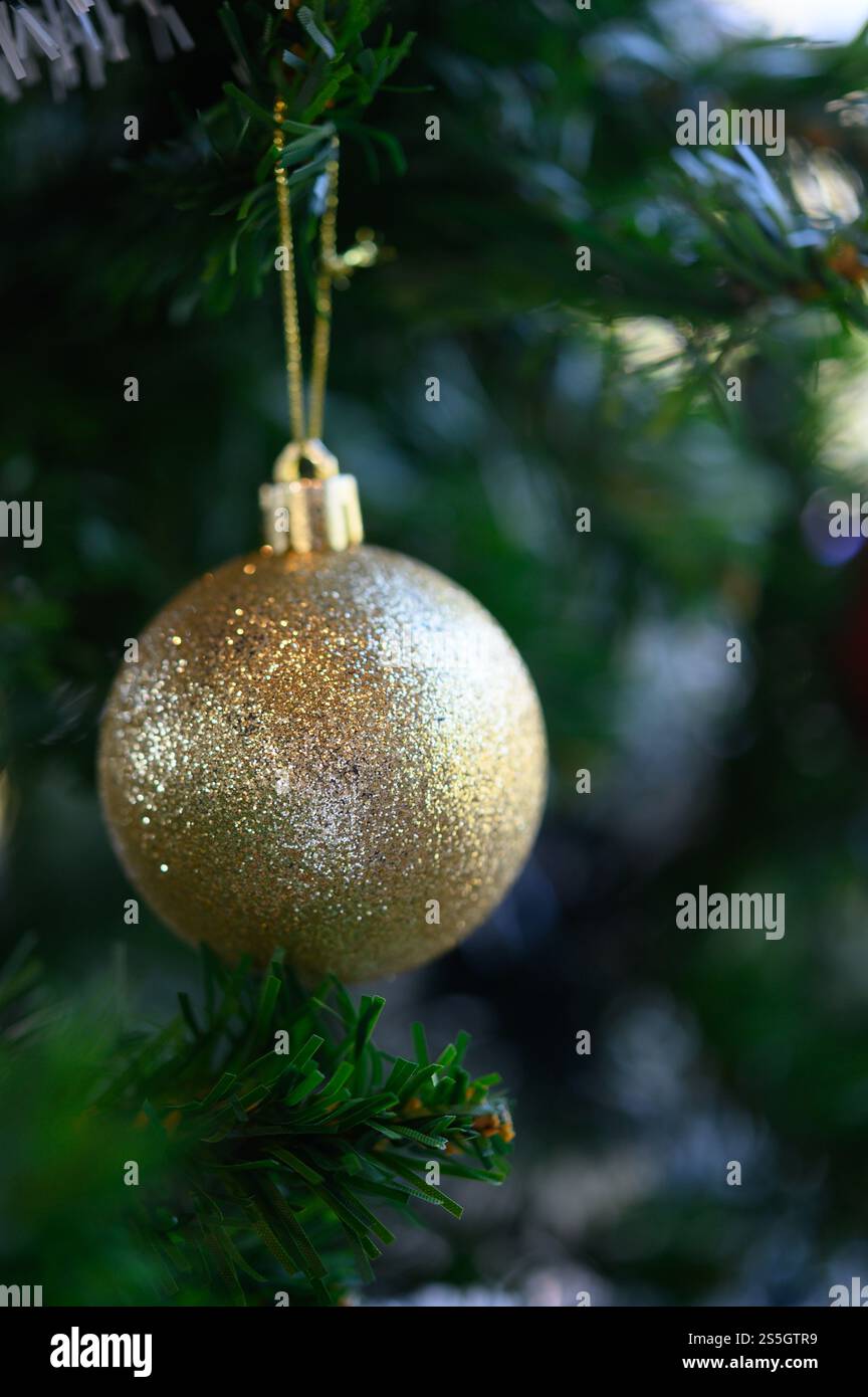 Nahaufnahme der goldenen Kugel, die am Weihnachtsbaum hängt. Stockfoto