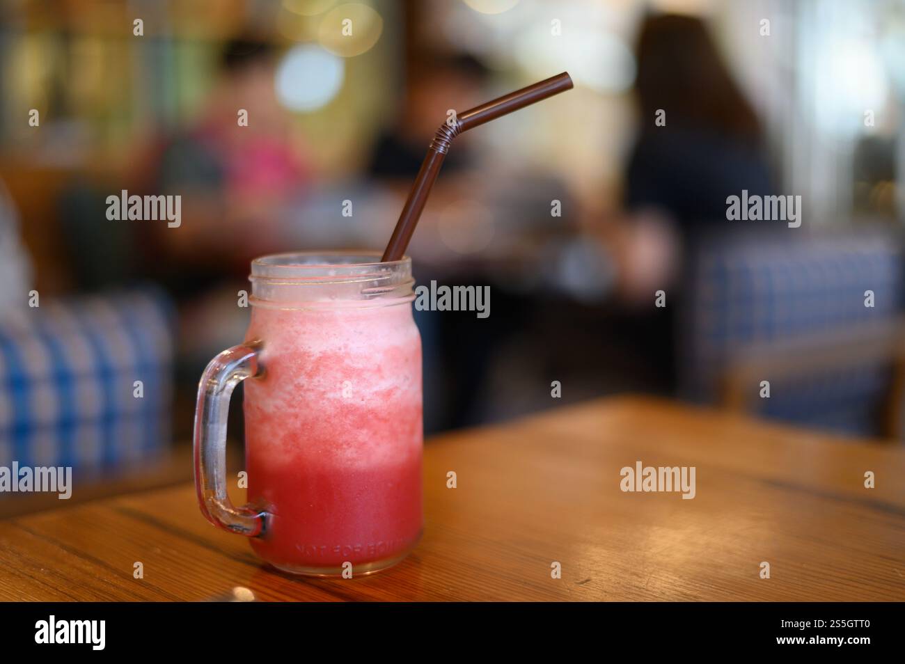 Rotes Wasser in einem Glas, auf einen Holztisch gestellt. Stockfoto