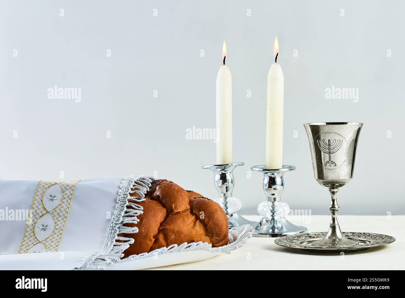 Einstellung Sabbath-Tisch. Eleganter Sabbattisch mit geflochtenem Brot, Kerzen und Weinbecher. Stockfoto