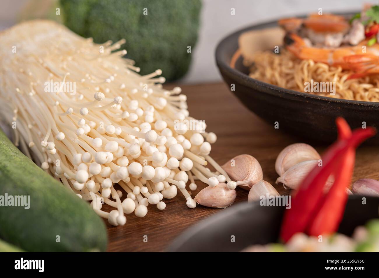 Goldener Nadelpilz, Papaya, Knoblauch und Chili auf Holztisch. Selektiver Fokus. Stockfoto