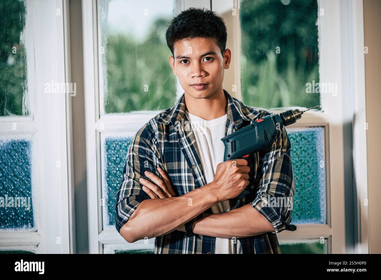 Der Zimmermann steht und hält einen Bohrer. Selektiver Fokus. Stockfoto