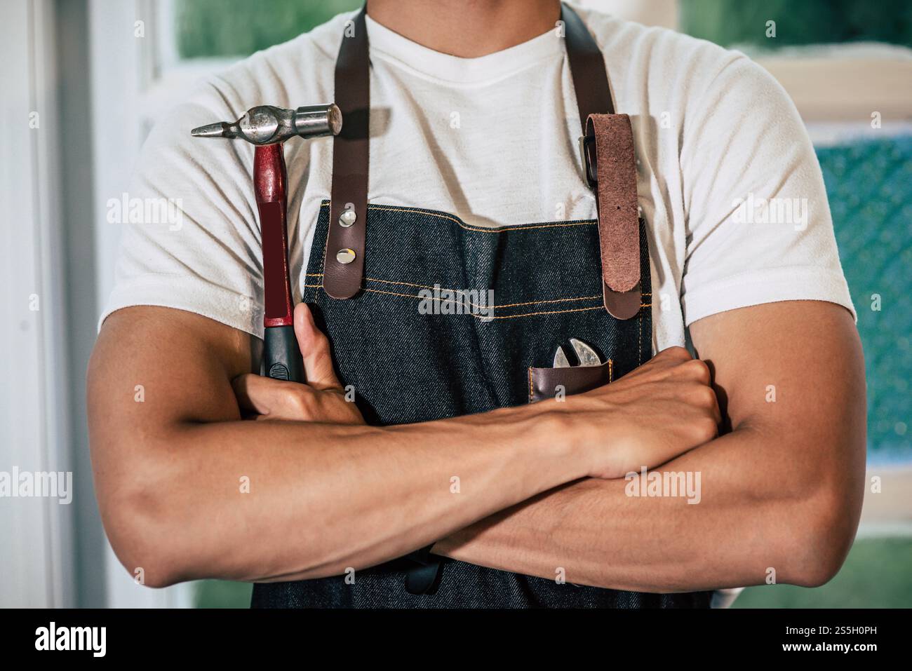 Der Zimmermann steht und hält einen Hammer. Selektiver Fokus Stockfoto