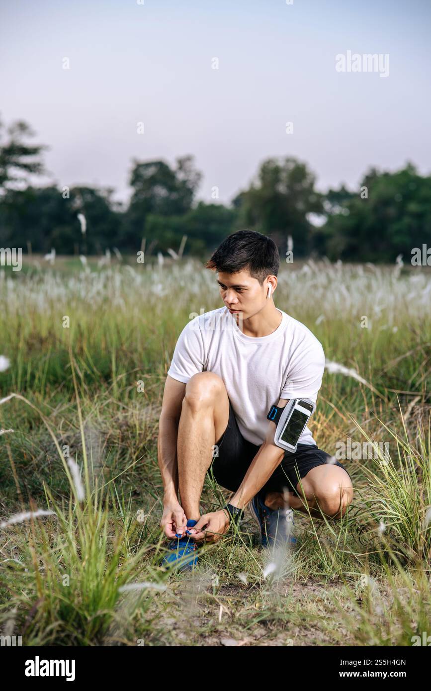 Der Mann schnürte sich einen Schnürsenkel, um zu trainieren. Selektiver Fokus. Stockfoto