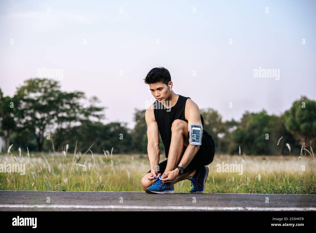 Der Mann schnürte sich einen Schnürsenkel, um zu trainieren. Selektiver Fokus. Stockfoto