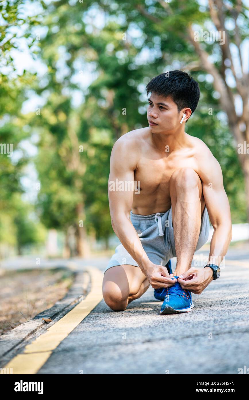 Der Mann schnürte sich einen Schnürsenkel, um zu trainieren. Selektiver Fokus. Stockfoto