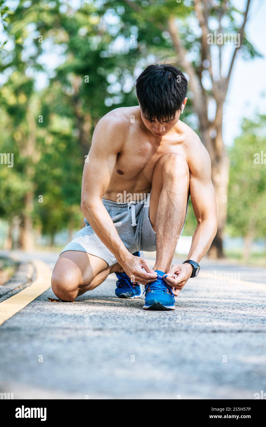 Der Mann schnürte sich einen Schnürsenkel, um zu trainieren. Selektiver Fokus. Stockfoto