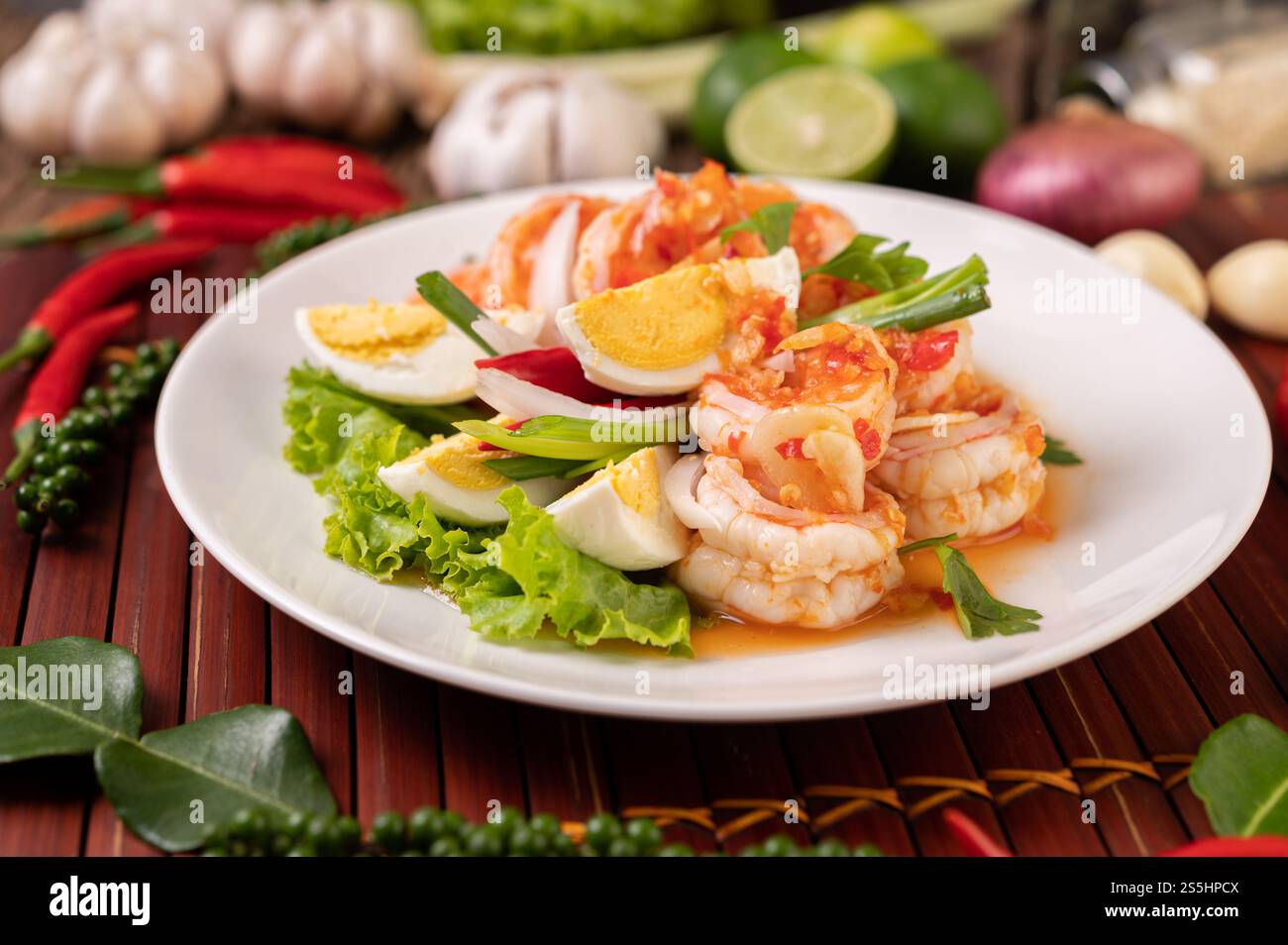 Garnelensalat mit gekochtem Eiersalat und gehackten Zwiebeln auf einer weißen Platte Stockfoto