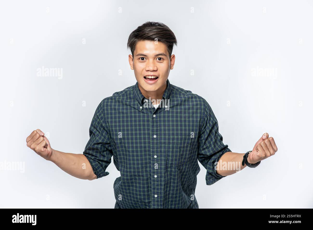 Der Mann in Schwarz hat beide Hände vor Freude geballt. Stockfoto