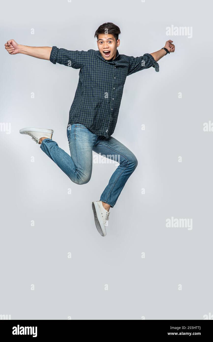 Der Mann in einem schwarzen Hemd und Jeans sprang vor Freude auf. Stockfoto