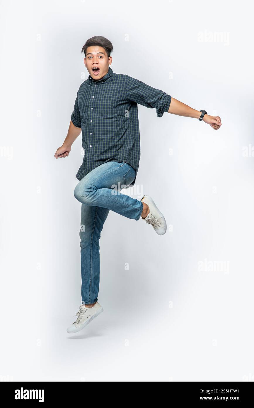 Der Mann in einem schwarzen Hemd und Jeans sprang vor Freude auf. Stockfoto