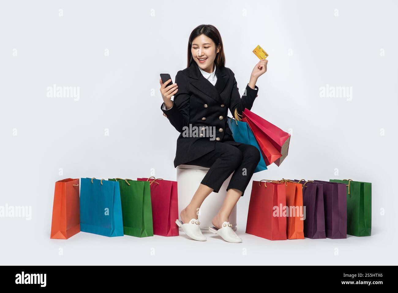 Die schwarz gekleidete Frau ging einkaufen, hatte Kreditkarten und viele Taschen dabei. Stockfoto