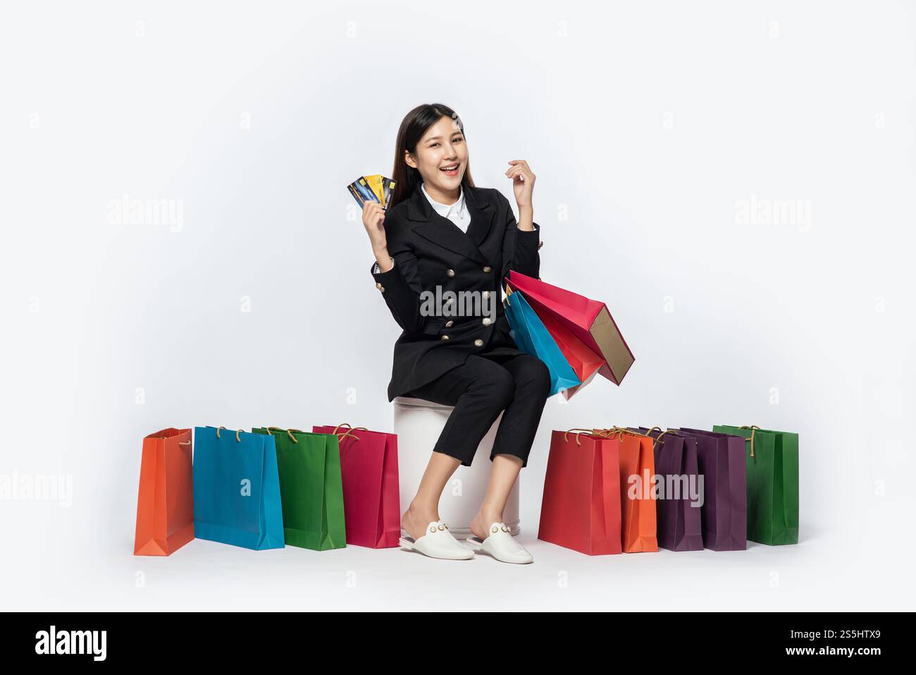 Die schwarz gekleidete Frau ging einkaufen, hatte Kreditkarten und viele Taschen dabei. Stockfoto