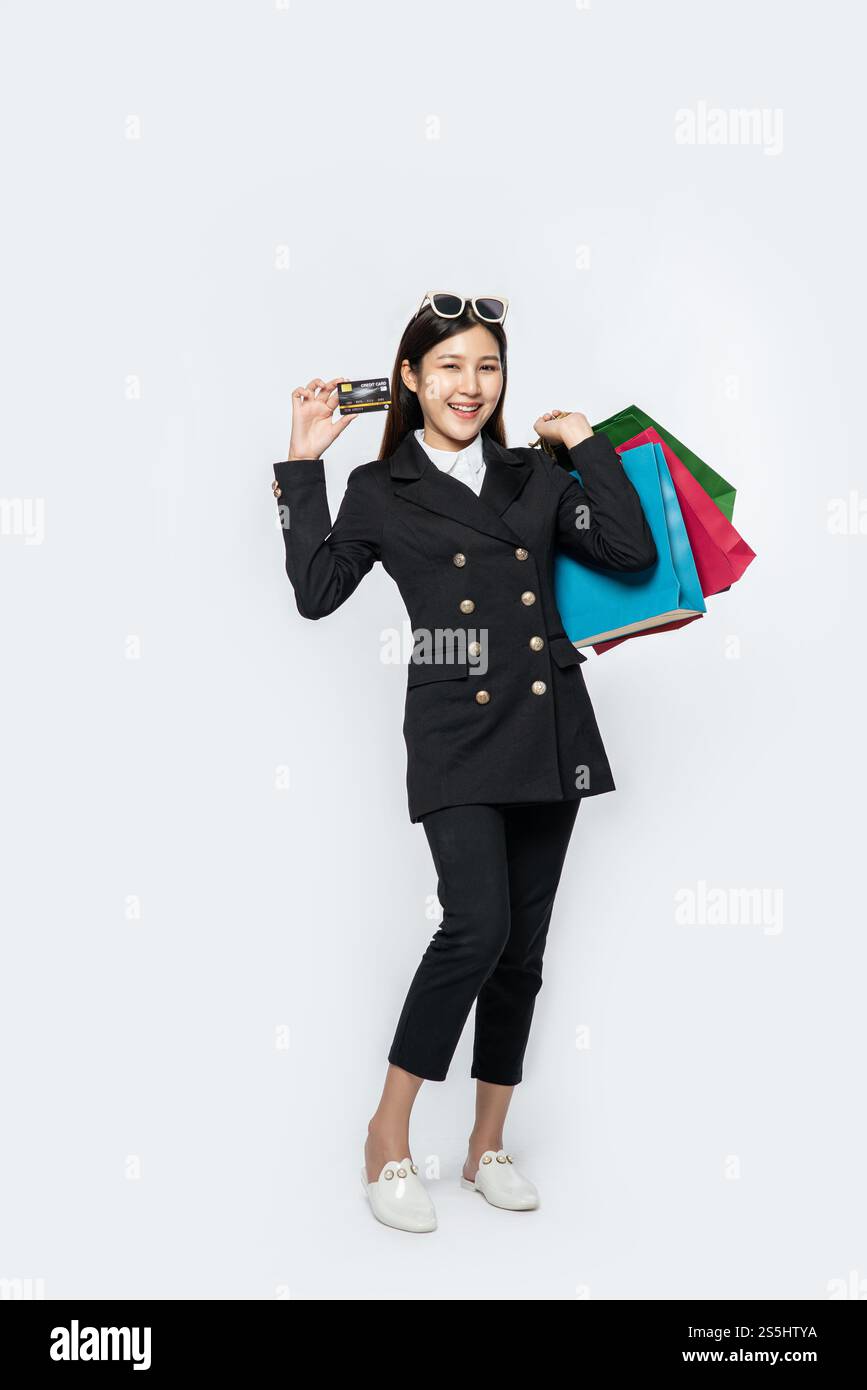 Die schwarz gekleidete Frau ging einkaufen, hatte Kreditkarten und viele Taschen dabei. Stockfoto