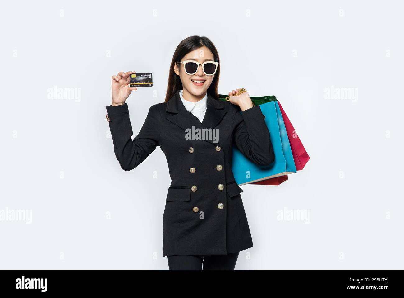 Frauen in Schwarz tragen Brillen, gehen einkaufen, haben Kreditkarten und viele Taschen. Stockfoto