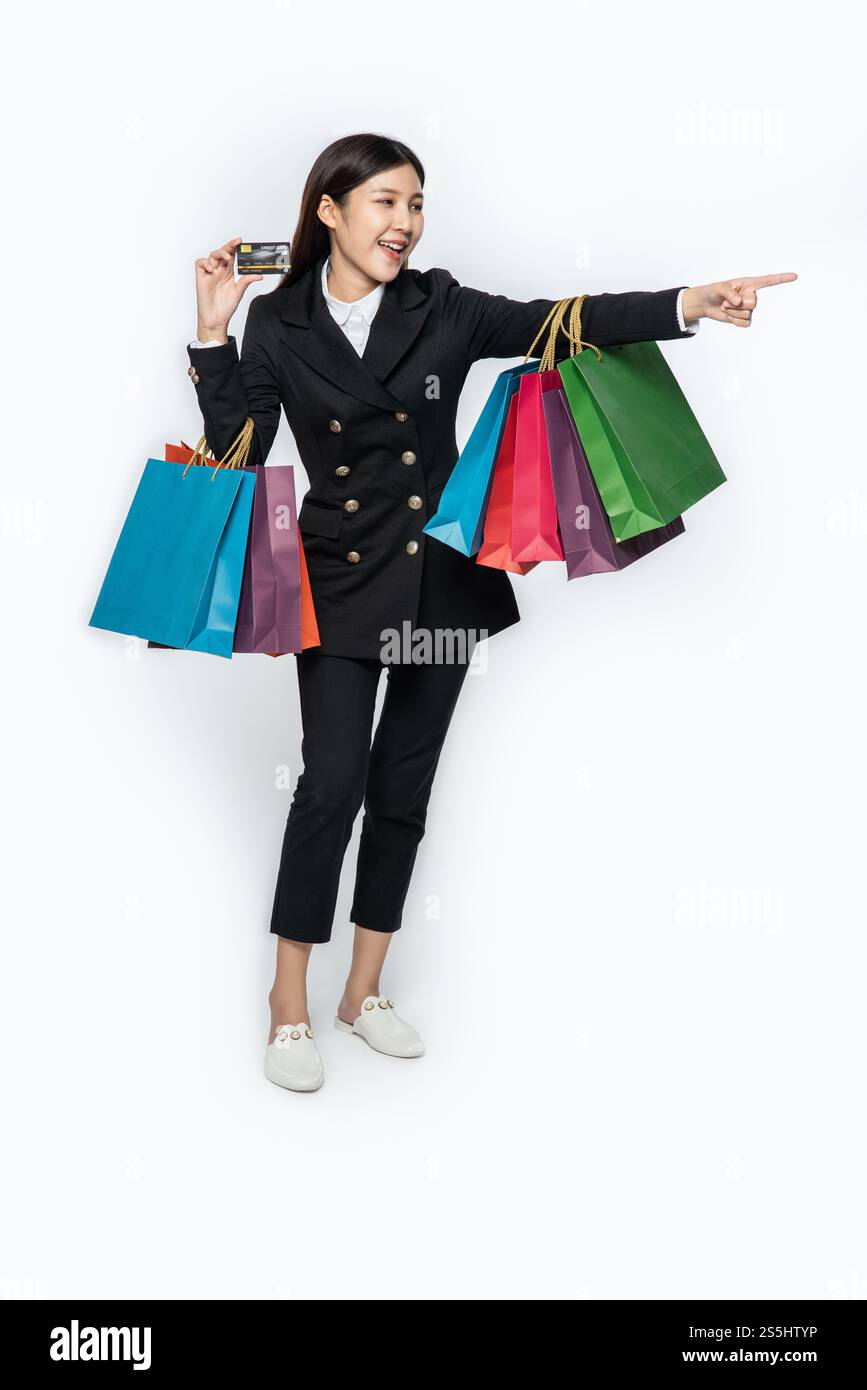 Die schwarz gekleidete Frau ging einkaufen, hatte Kreditkarten und viele Taschen dabei. Stockfoto