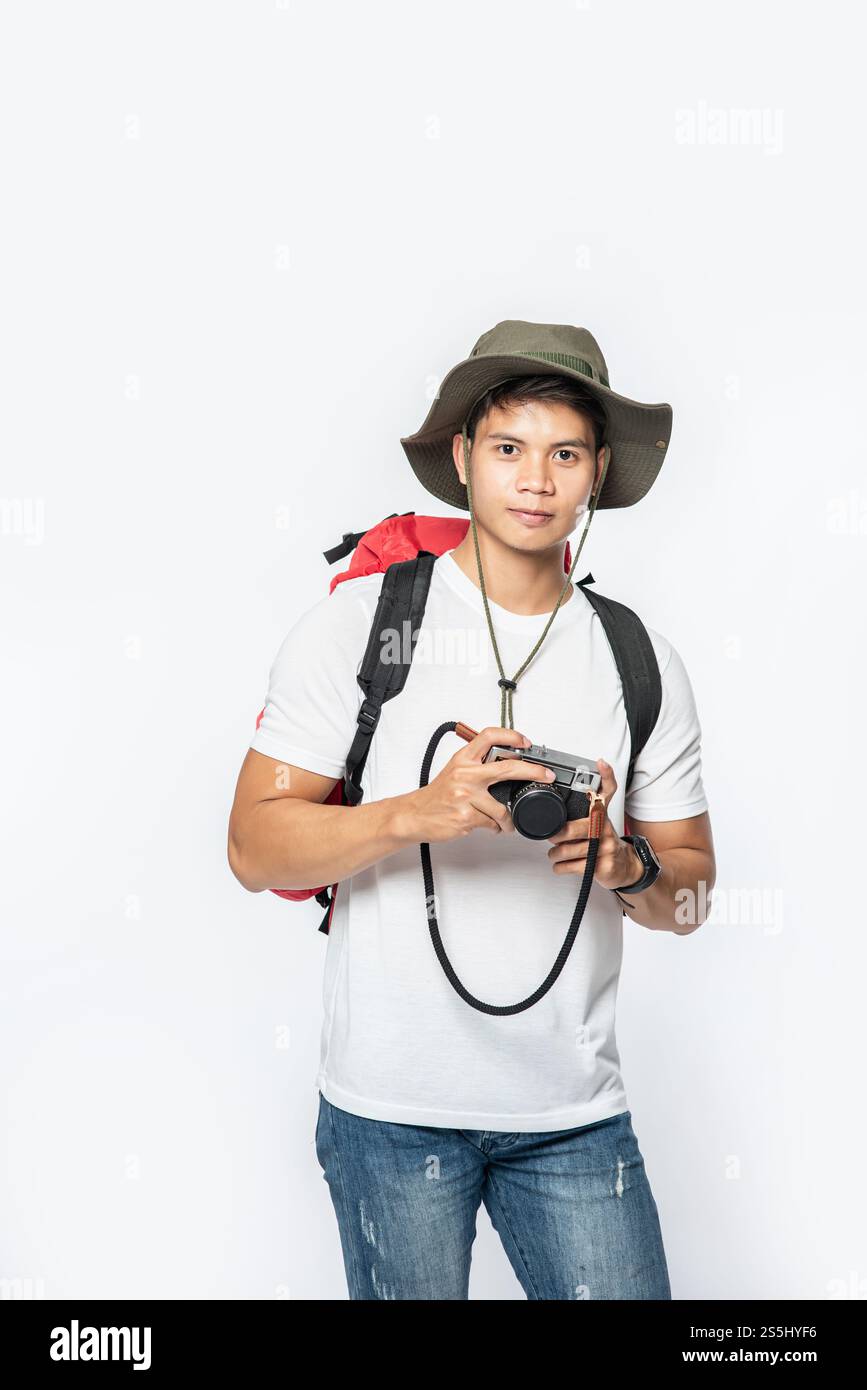 Ein Mann, der mit Hut unterwegs ist und eine Kamera nimmt Stockfoto