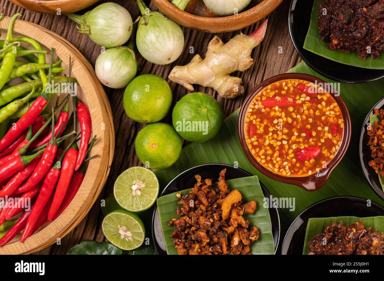 Verschiedene Arten von Chilisauce in einer Tasse mit Zutaten für die Zubereitung Stockfoto