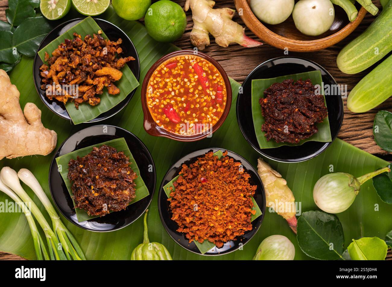 Verschiedene Arten von Chilisauce in einer Tasse mit Zutaten für die Zubereitung Stockfoto