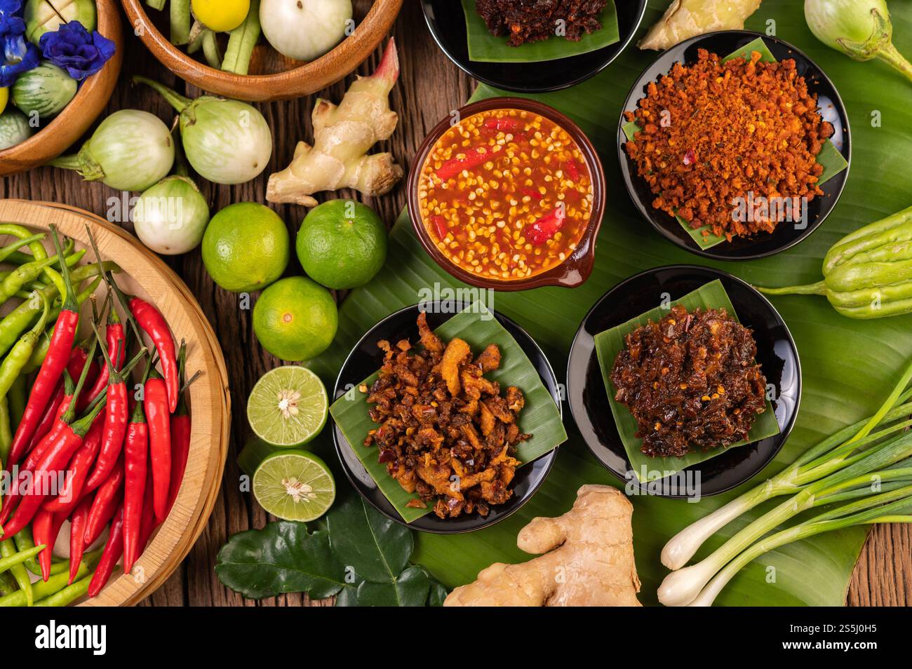 Verschiedene Arten von Chilisauce in einer Tasse mit Zutaten für die Zubereitung Stockfoto