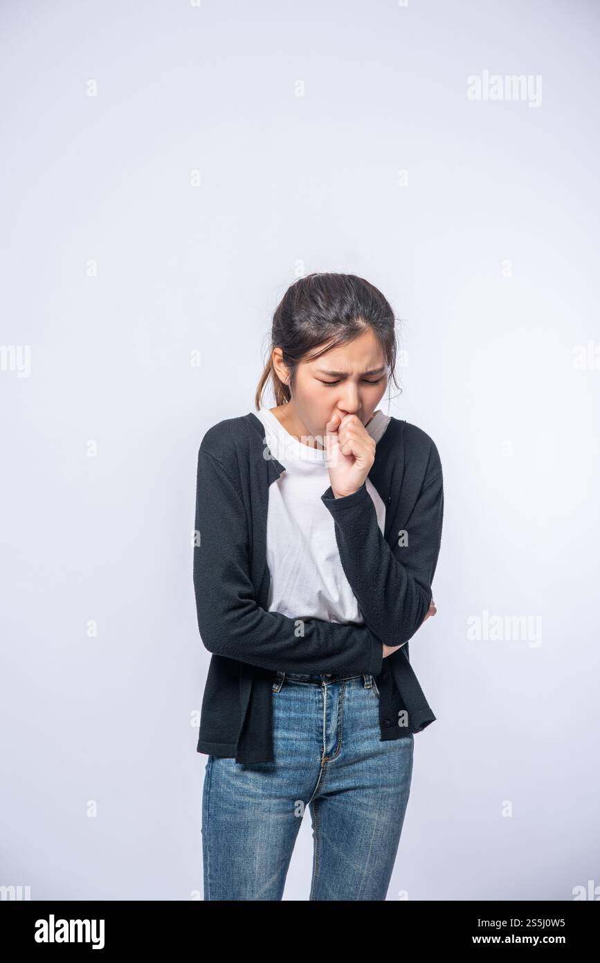 Eine Frau, die hustet und ihren Mund mit der Hand bedeckt Stockfoto