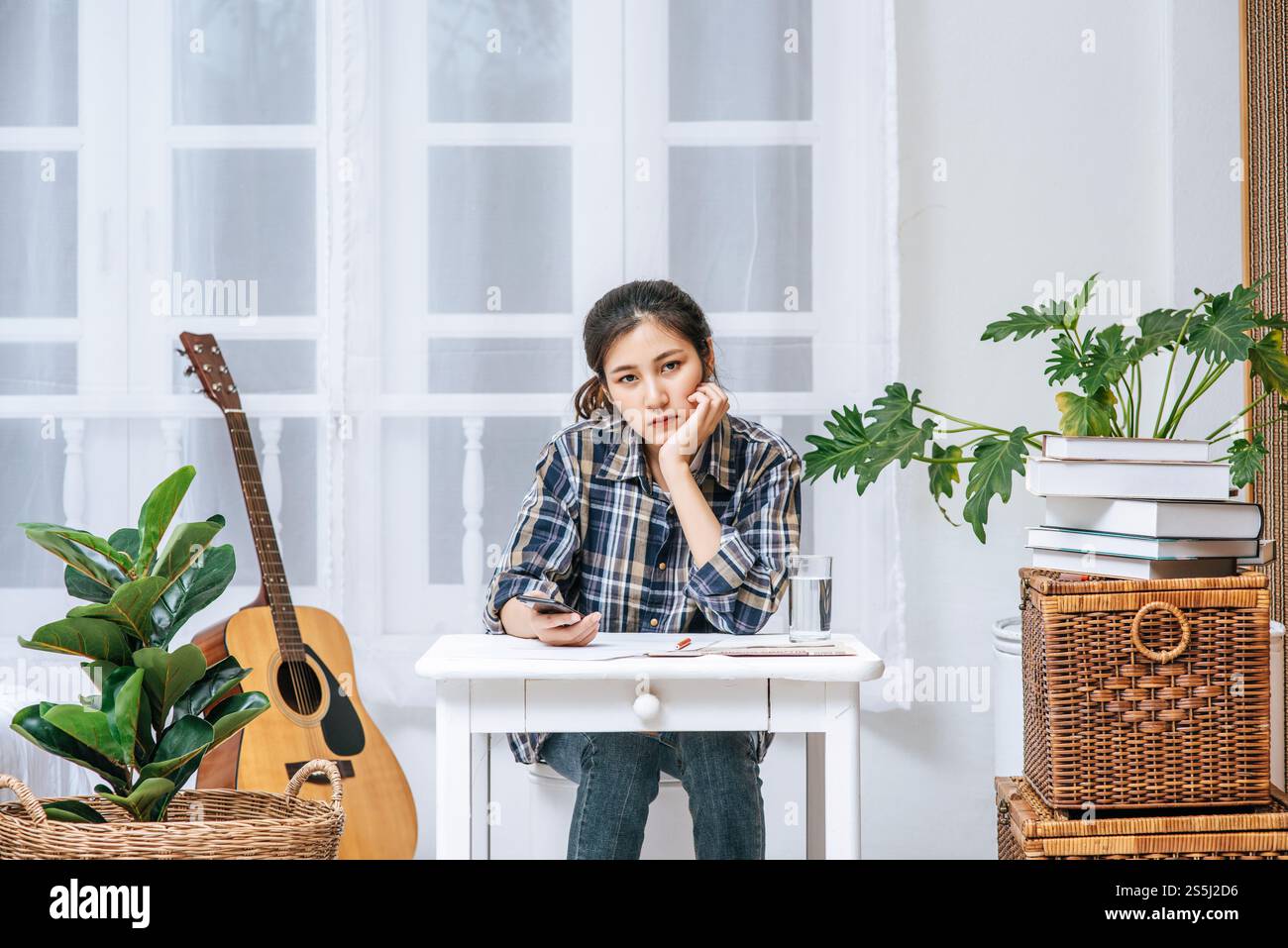 Eine Frau, die an einem Schreibtisch sitzt, analysiert das Dokument und ist gestresst. Stockfoto