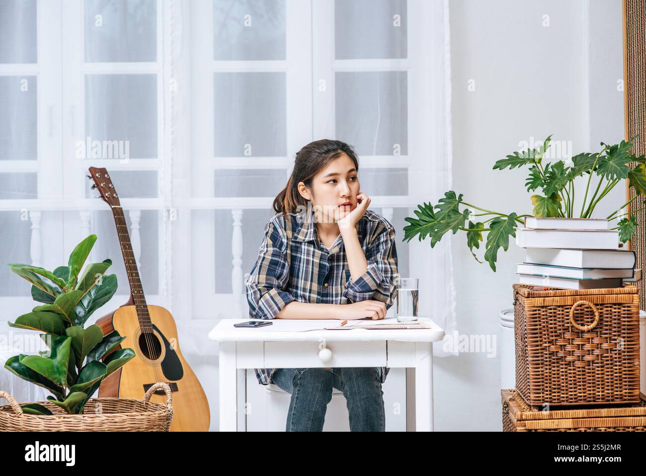 Eine Frau, die an einem Schreibtisch sitzt, analysiert das Dokument und ist gestresst. Stockfoto