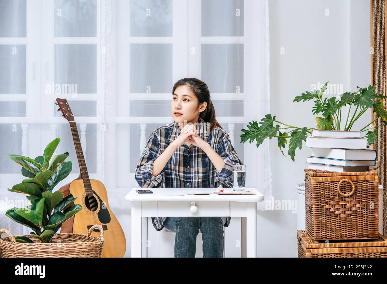 Eine Frau, die an einem Schreibtisch sitzt, analysiert das Dokument und ist gestresst. Stockfoto