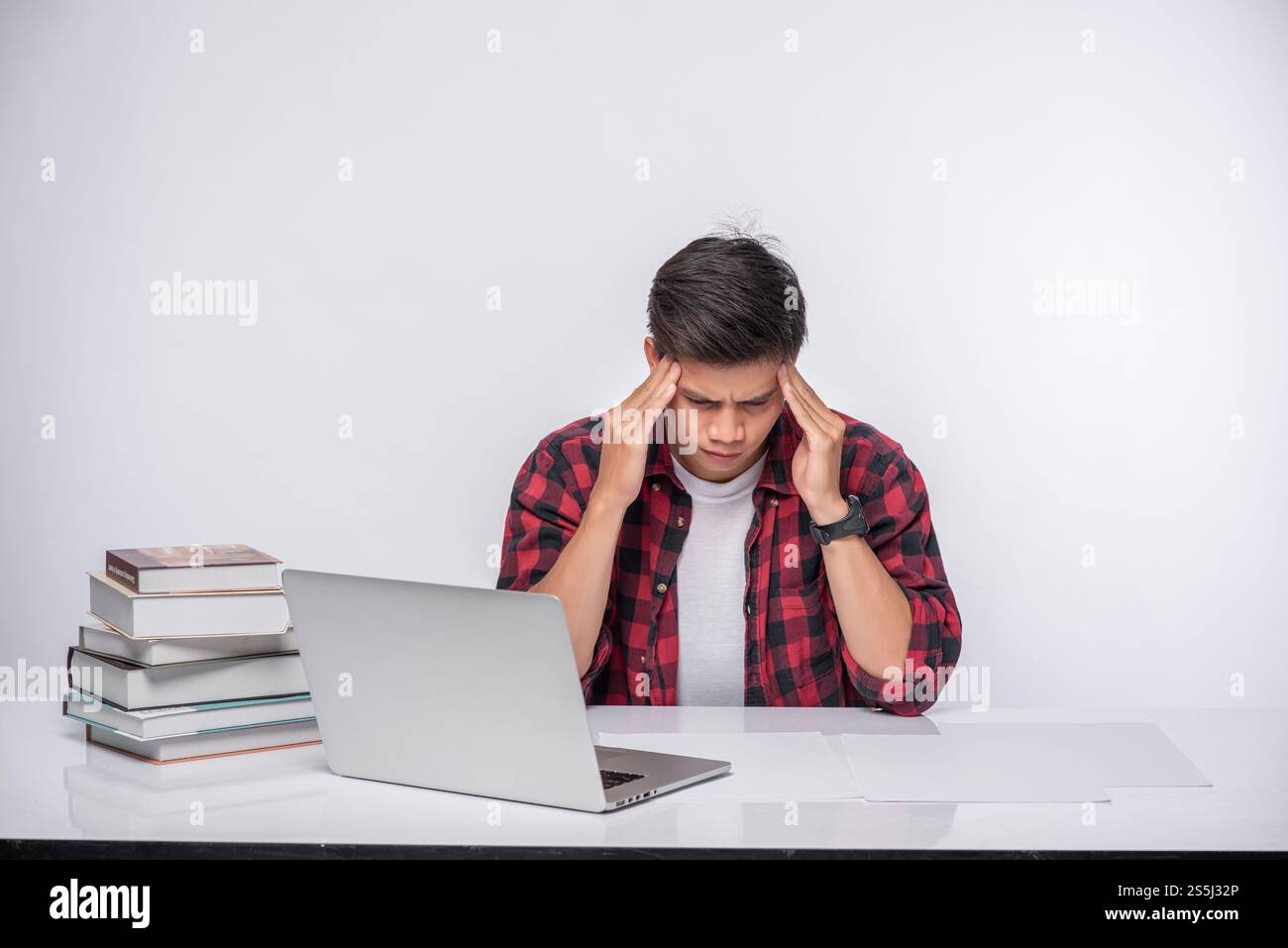 Männer benutzen Laptops im Büro und sind gestresst. Stockfoto