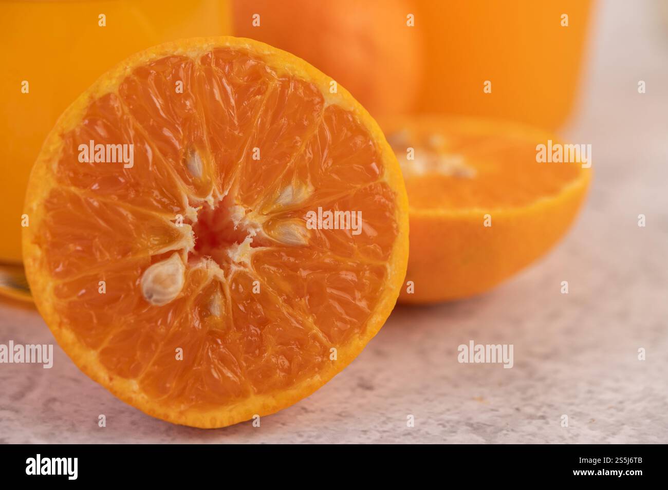 In der Hälfte geschnittene Orangen und Orangensaft. Stockfoto
