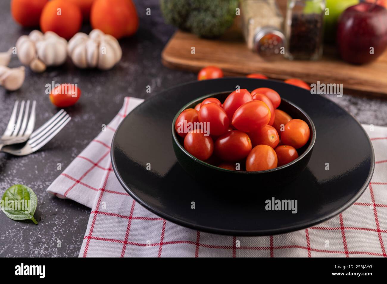 Die Tomaten sind im schwarzen Becher. Selektiver Fokus. Stockfoto