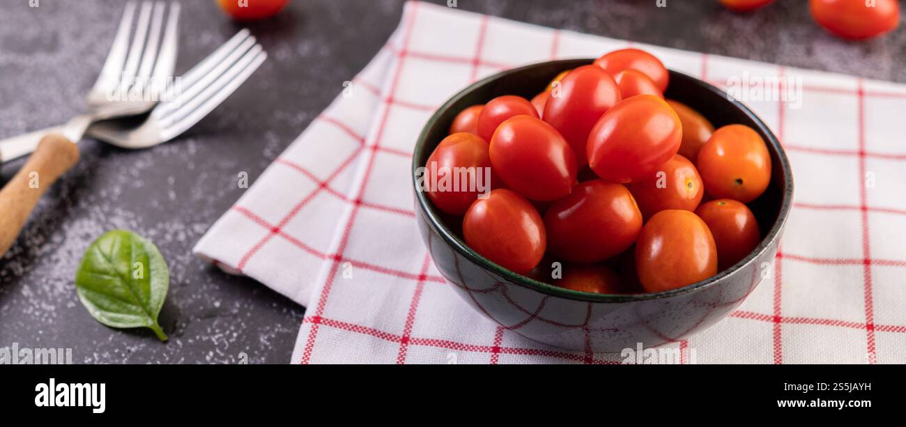 Die Tomaten sind im schwarzen Becher. Selektiver Fokus. Stockfoto