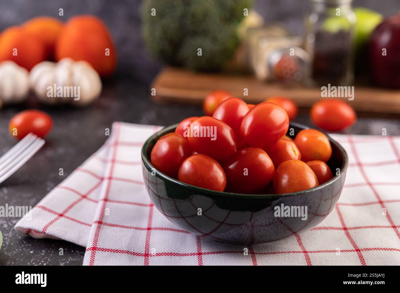 Die Tomaten sind im schwarzen Becher. Selektiver Fokus. Stockfoto