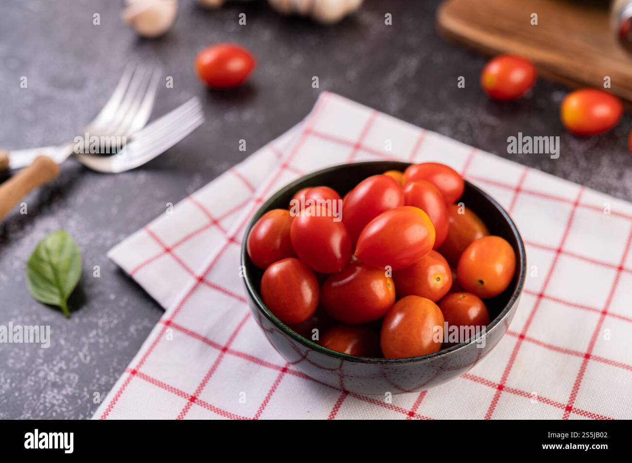 Die Tomaten sind im schwarzen Becher. Selektiver Fokus. Stockfoto
