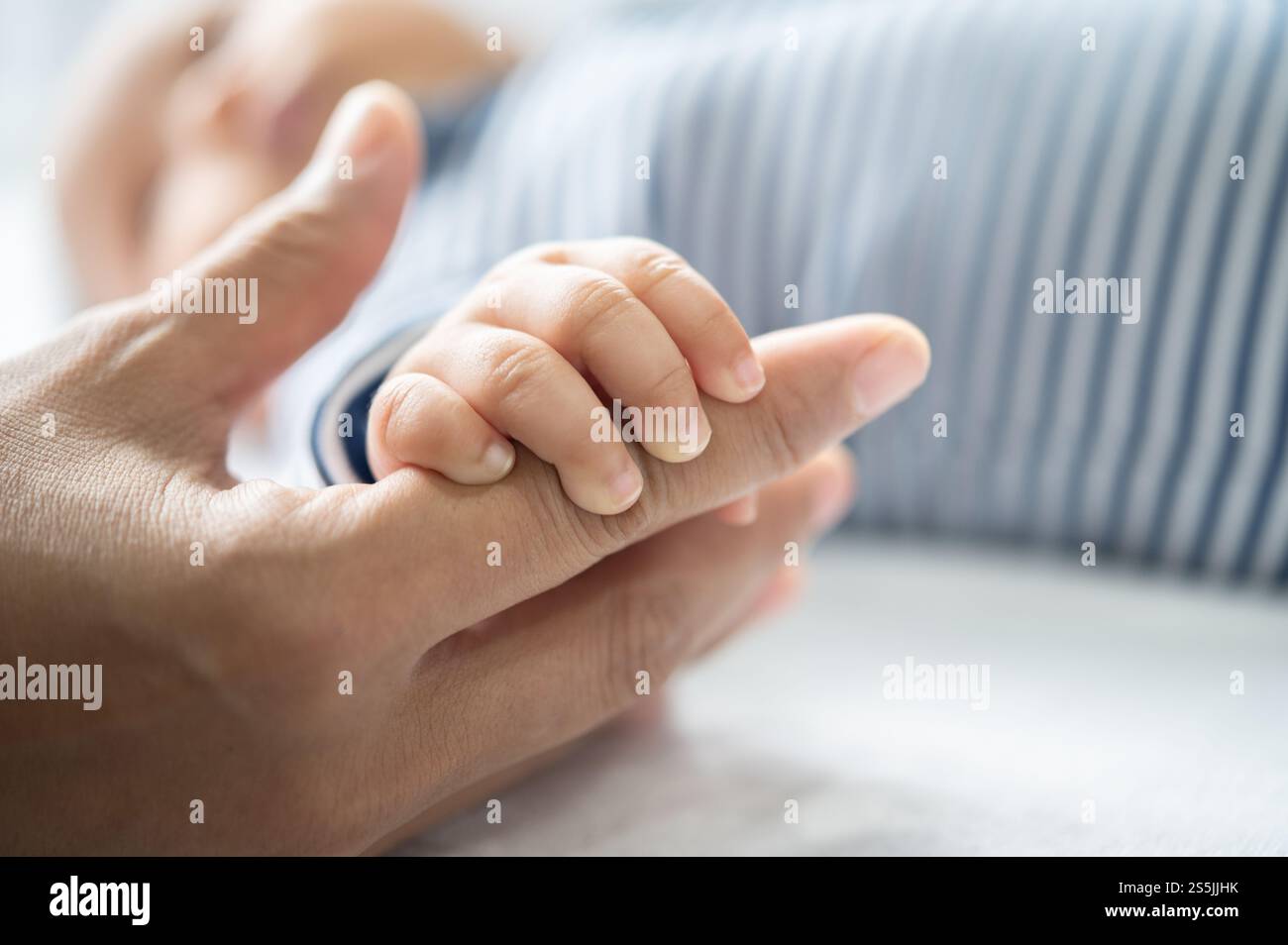 Die Hand des Neugeborenen, die die Finger der Mutter hält Stockfoto