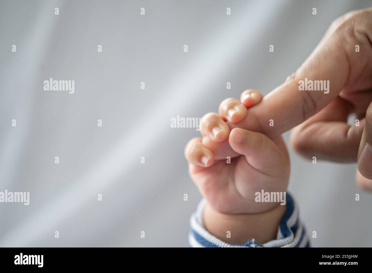 Die Hand des Neugeborenen, die die Finger der Mutter hält Stockfoto