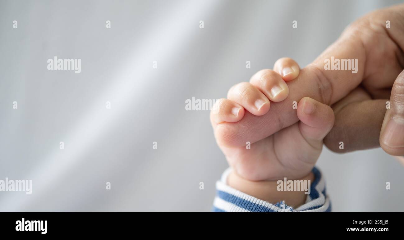 Die Hand des Neugeborenen, die die Finger der Mutter hält Stockfoto