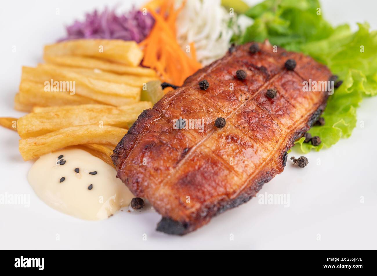 Fischsteak mit Pommes frites, Kiwi, Salat, Karotten, Tomaten, und Kohl in einer weißen Schale Stockfoto
