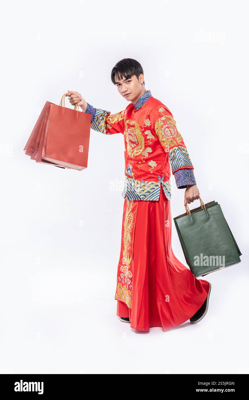 Mann trägt Cheongsam Anzug Lächeln mit Papiertüte vom Einkaufen im chinesischen Neujahr Stockfoto