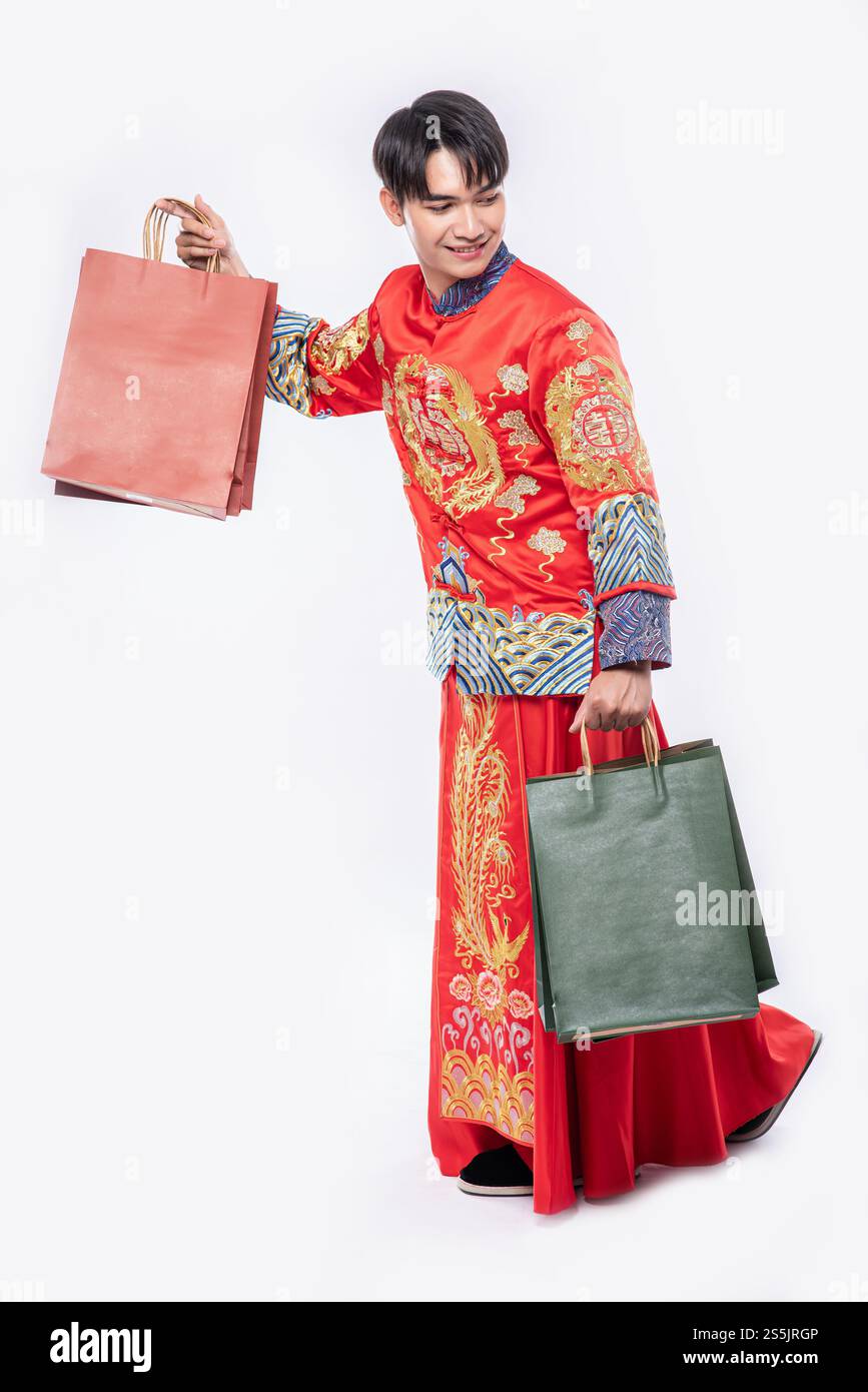 Mann trägt Cheongsam Anzug Lächeln mit Papiertüte vom Einkaufen im chinesischen Neujahr Stockfoto
