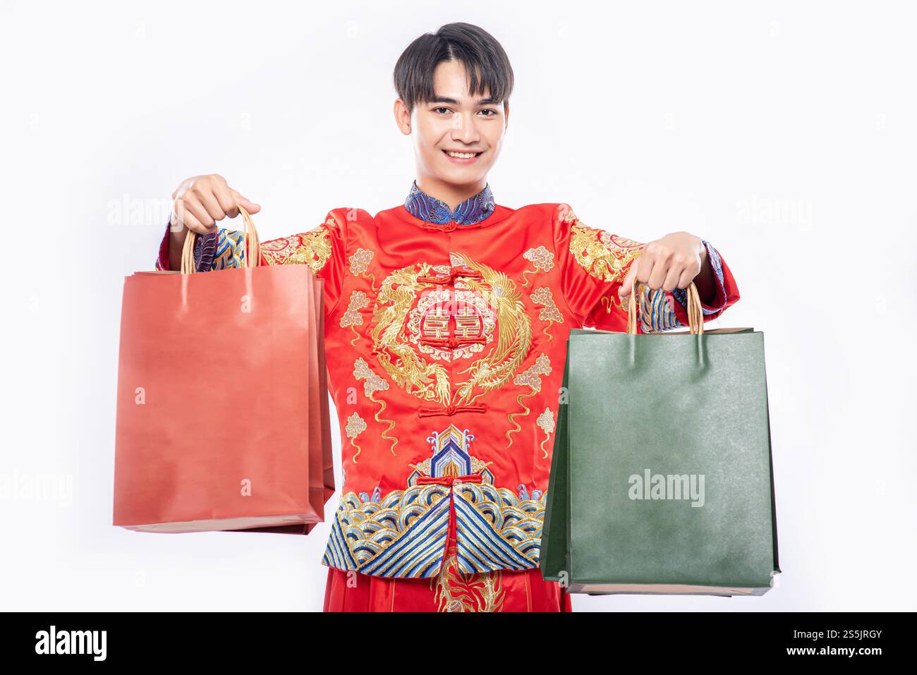 Mann trägt Cheongsam Anzug Lächeln mit Papiertüte vom Einkaufen im chinesischen Neujahr Stockfoto