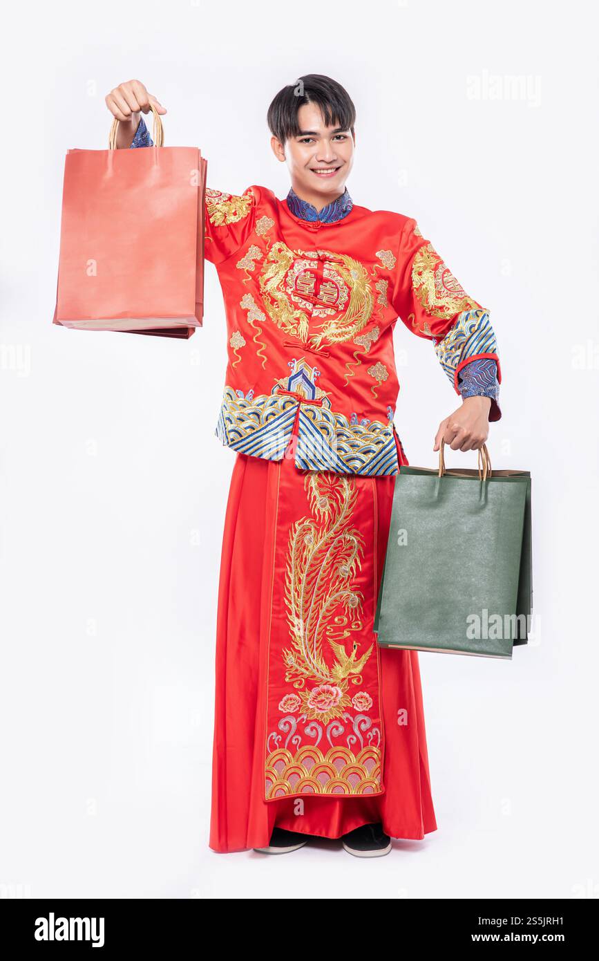 Mann trägt Cheongsam Anzug Lächeln mit Papiertüte vom Einkaufen im chinesischen Neujahr Stockfoto
