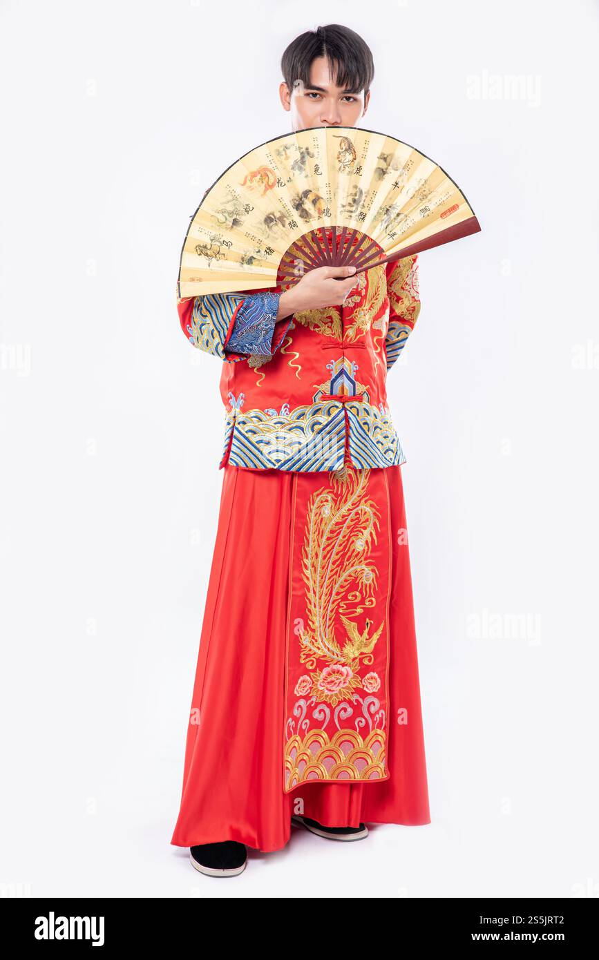 Man trägt Cheongsam Anzug und zeigt den chinesischen Handfan auf einem großen Event im chinesischen Neujahr Stockfoto