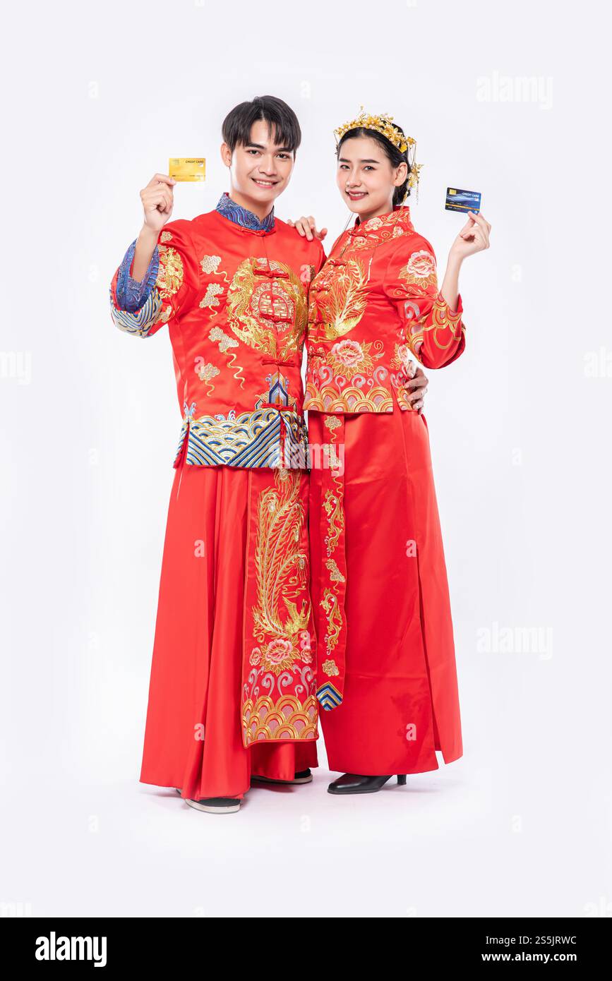 Männer und Frauen, die Qipao tragen, gehen mit Kreditkarten einkaufen. Stockfoto