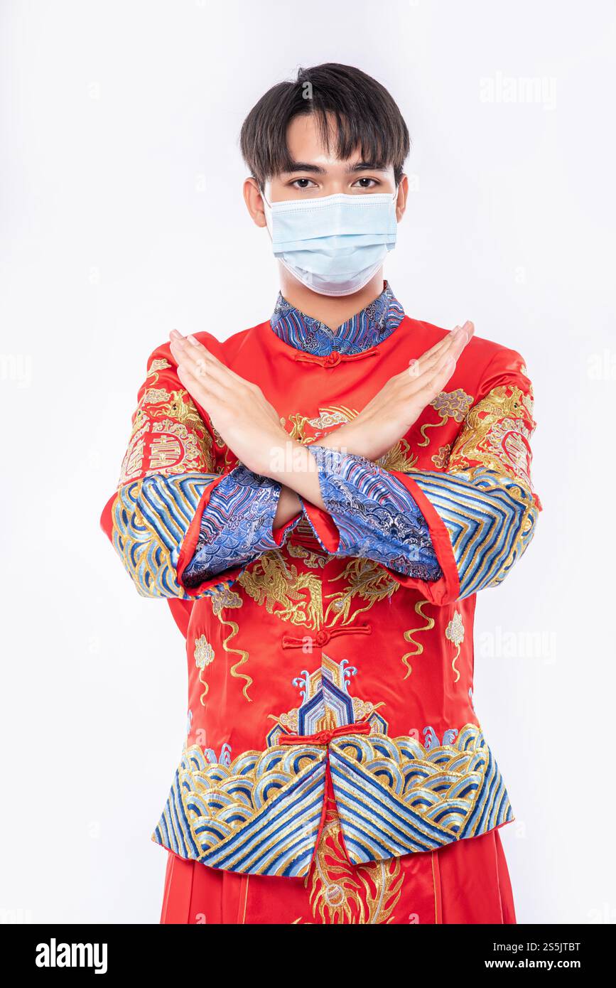 Mann tragen Cheongsam Anzug und Maske Show Leute nicht tragen Maske kann nicht kommen, um im chinesischen Neujahr einzukaufen Stockfoto