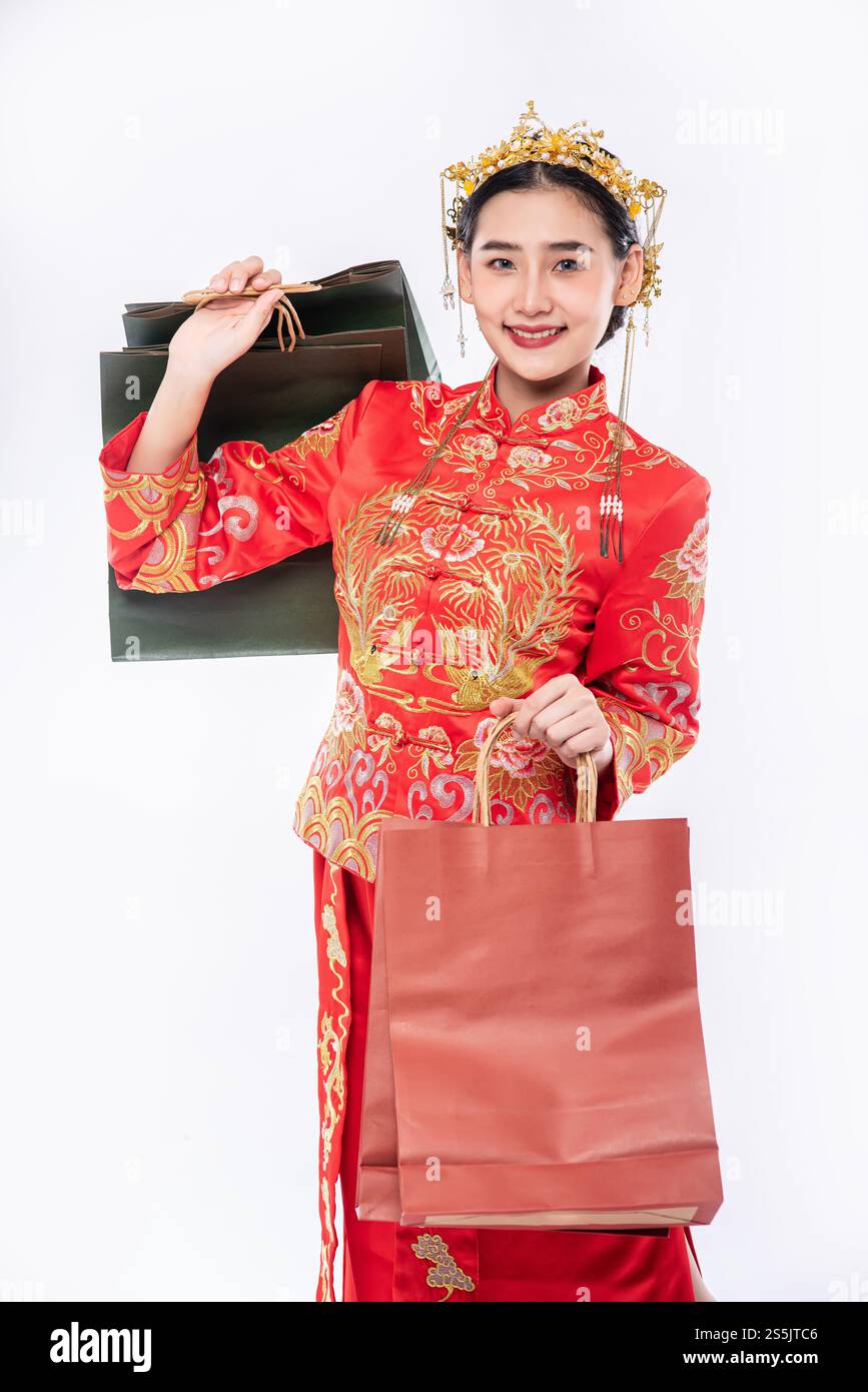 Frau trägt Cheongsam Anzug Lächeln mit Papiertüte vom Einkaufen im chinesischen Neujahr Stockfoto