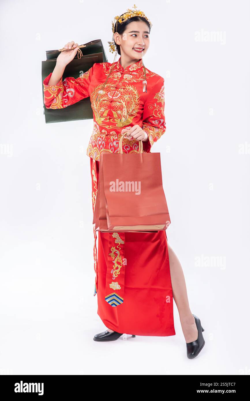 Frau trägt Cheongsam Anzug Lächeln mit Papiertüte vom Einkaufen im chinesischen Neujahr Stockfoto