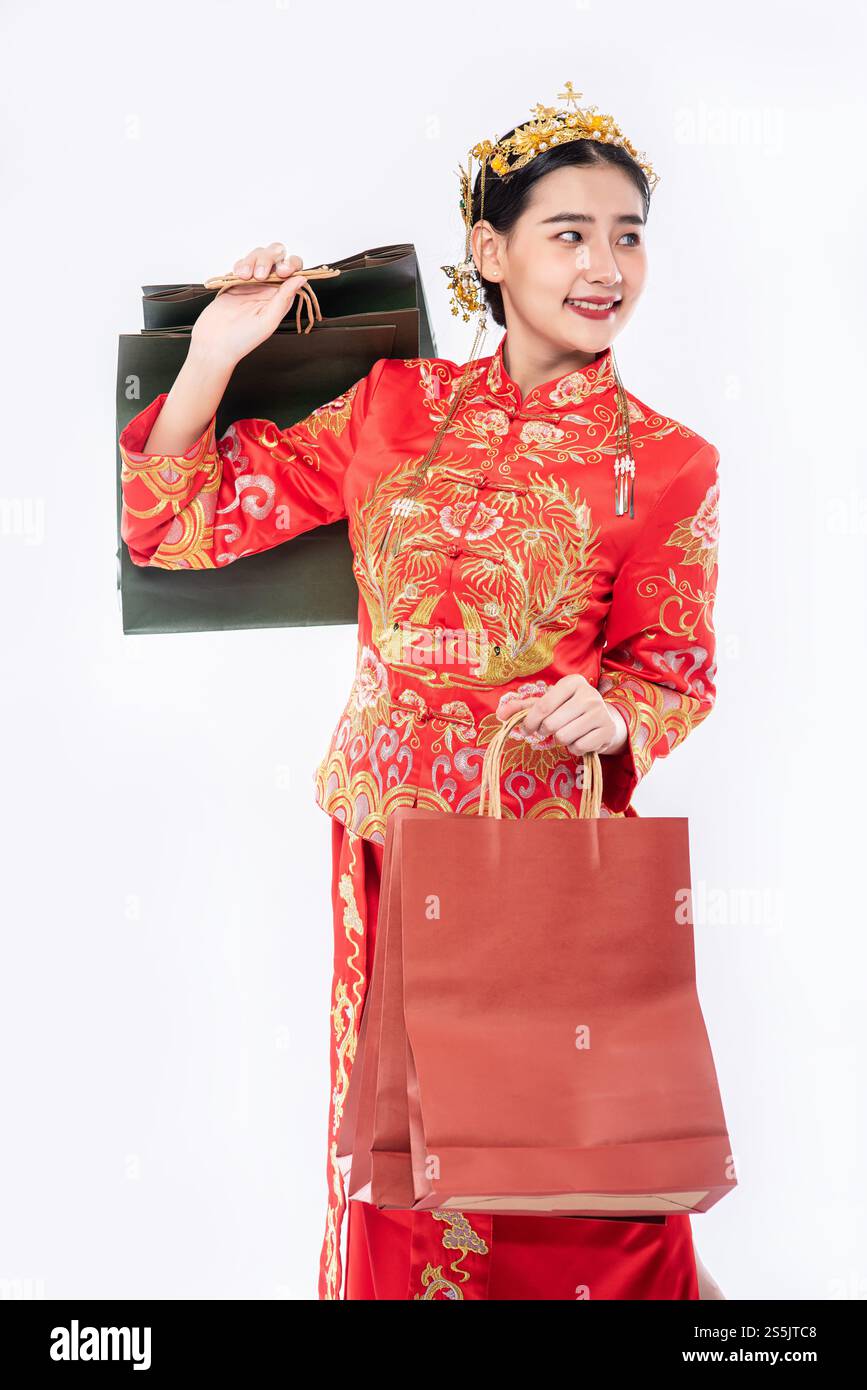 Frau trägt Cheongsam Anzug Lächeln mit Papiertüte vom Einkaufen im chinesischen Neujahr Stockfoto