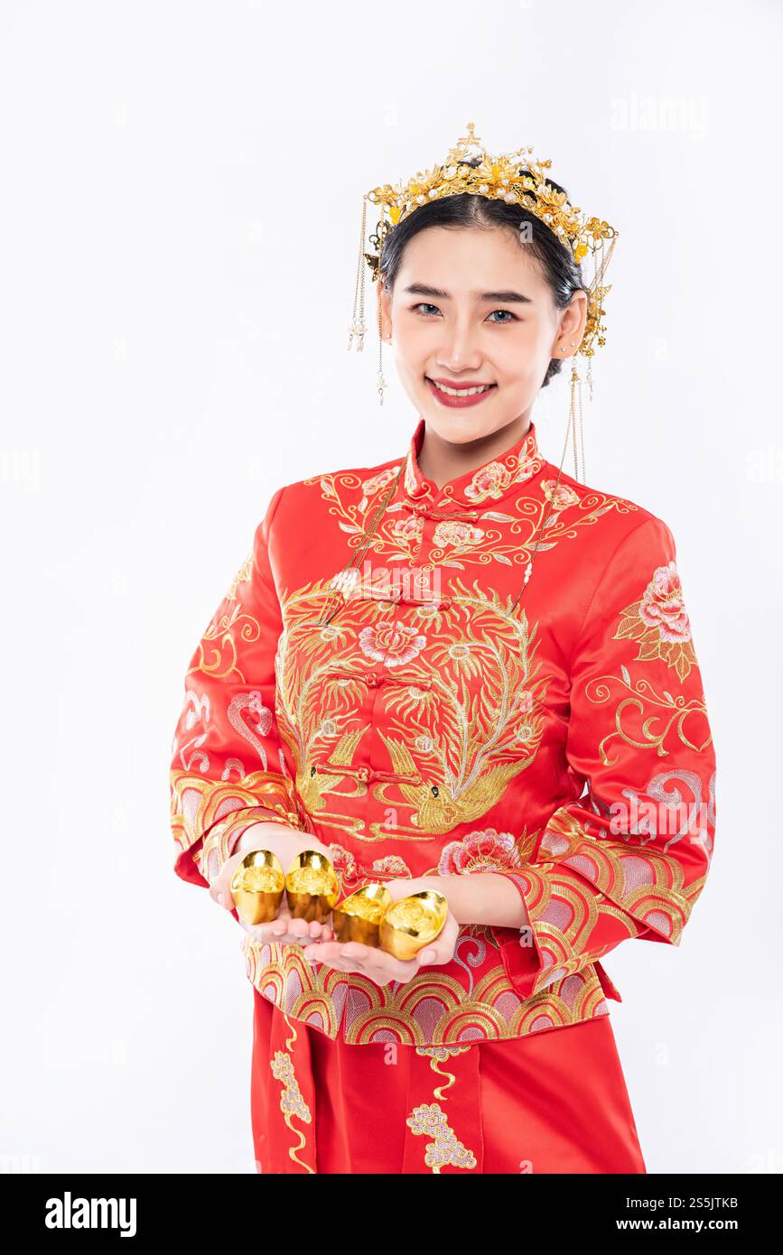 Frau trägt Cheongsam-Anzug Gib ihrer Familie Gold zum Glück im chinesischen Neujahr Stockfoto