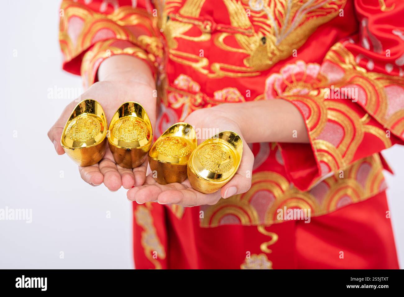 Frau trägt Cheongsam-Anzug Gib ihrer Familie Gold zum Glück im chinesischen Neujahr Stockfoto