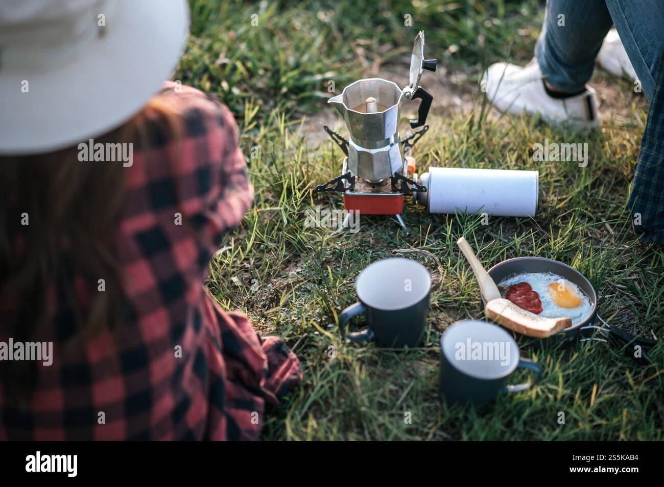 Close-up Kaffeekanne und Frühstück für Wohnmobile Pärchen Platz auf Rasen, Ausrüstung für Camping-Ausflug im Sommerurlaub Stockfoto